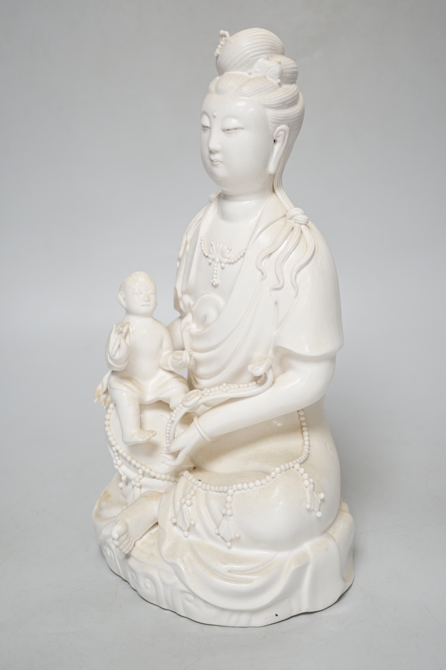 A blanc de chine figure of Guanyin and a child, 27cm